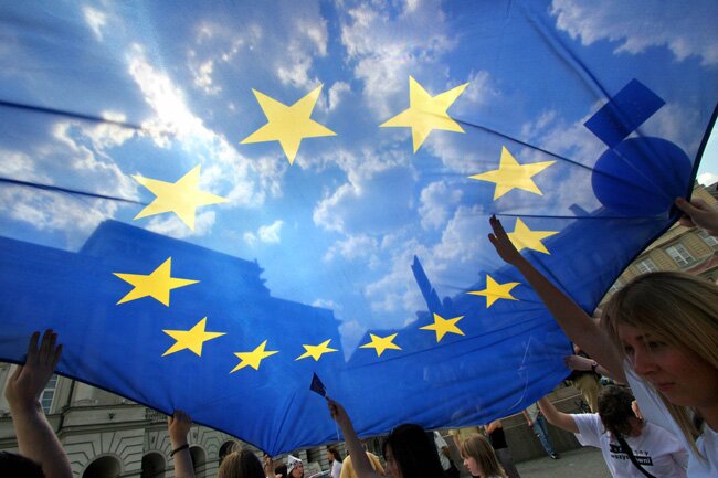 People hold an European Union flag during an EU parade in central Warsaw May 13, 2006. REUTERS/Katarina Stoltz