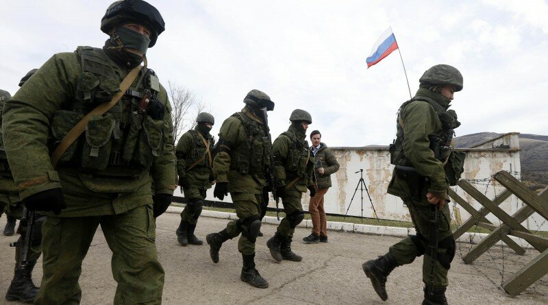 Uniformed men, believed to be Russian servicemen, walk in formation near a Ukrainian military base in the village of Perevalnoye, outside Simferopol, March 6, 2014. Crimea's parliament voted to join Russia on Thursday and its Moscow-backed government set a referendum within 10 days on the decision in a dramatic escalation of the crisis over the Ukrainian Black Sea peninsula. REUTERS/Vasily Fedosenko (UKRAINE - Tags: CIVIL UNREST MILITARY POLITICS)